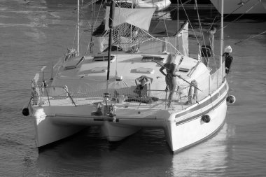 Italy, Sicily, Mediterranean Sea, Marina di Ragusa (Ragusa Province); 27 August 2022, people on a catamaran sailing boat and luxury yachts in the port - EDITORIAL