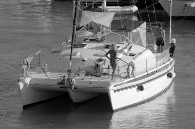 Italy, Sicily, Mediterranean Sea, Marina di Ragusa (Ragusa Province); 27 August 2022, people on a catamaran sailing boat and luxury yachts in the port - EDITORIAL