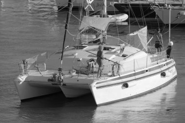 Italy, Sicily, Mediterranean Sea, Marina di Ragusa (Ragusa Province); 27 August 2022, people on a catamaran sailing boat and luxury yachts in the port - EDITORIAL