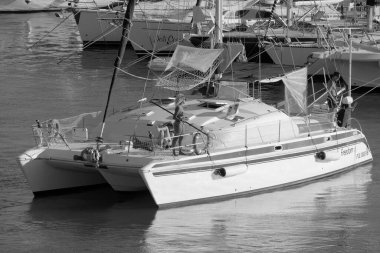 Italy, Sicily, Mediterranean Sea, Marina di Ragusa (Ragusa Province); 27 August 2022, people on a catamaran sailing boat and luxury yachts in the port - EDITORIAL