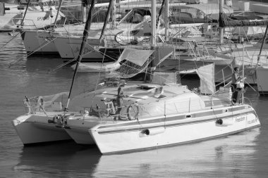 Italy, Sicily, Mediterranean Sea, Marina di Ragusa (Ragusa Province); 27 August 2022, people on a catamaran sailing boat and luxury yachts in the port - EDITORIAL