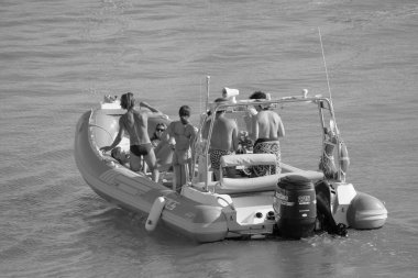 Italy, Sicily, Mediterranean Sea, Marina di Ragusa (Ragusa Province); 28 August 2022, people on a rubber boat in the port - EDITORIAL