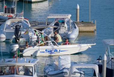 Italy, Sicily, Mediterranean Sea, Marina di Ragusa (Ragusa Province); 28 August 2022, people on a motor boat in the port - EDITORIAL