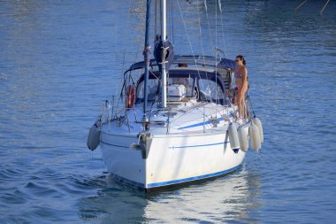 Italy, Sicily, Mediterranean Sea, Marina di Ragusa (Ragusa Province); 28 August 2022, couple on a sailing boat in the port - EDITORIAL