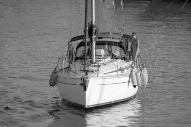 Italy, Sicily, Mediterranean Sea, Marina di Ragusa (Ragusa Province); 28 August 2022, couple on a sailing boat in the port - EDITORIAL
