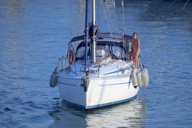 Italy, Sicily, Mediterranean Sea, Marina di Ragusa (Ragusa Province); 28 August 2022, couple on a sailing boat in the port - EDITORIAL
