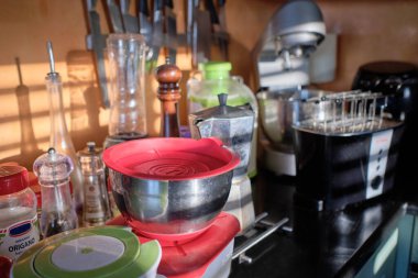 Italy, Sicily, Marina di Ragusa (Ragusa Province); cooking items and spices on the kitchen counter, lit by the sun rays coming from a window 