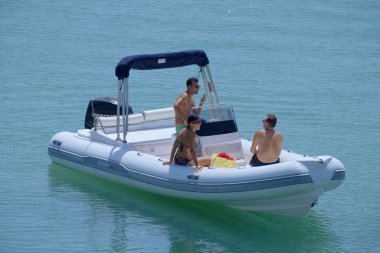 Italy, Sicily, Mediterranean Sea, Marina di Ragusa (Ragusa Province); 3 September 2022, people on a rubber boat in the port - EDITORIAL