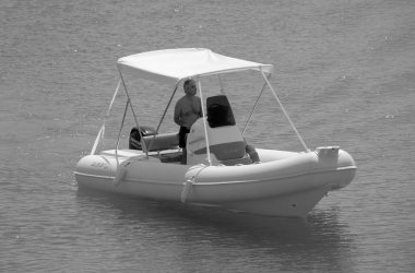 Italy, Sicily, Mediterranean Sea, Marina di Ragusa (Ragusa Province); 3 September 2022, man on a rubber boat in the port - EDITORIAL