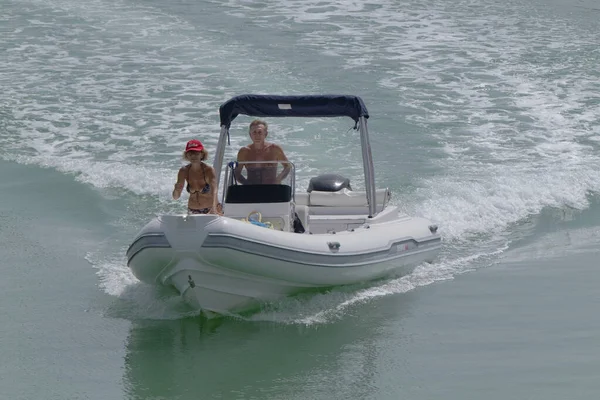 İtalya, Sicilya, Akdeniz, Marina di Ragusa (Ragusa Eyaleti); 9 Eylül 2022, limanda kauçuk bir tekne ve lüks yatlarda bir çift - EDITORIAL