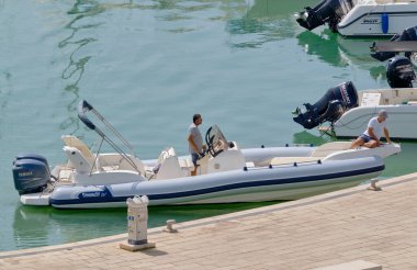 İtalya, Sicilya, Akdeniz, Marina di Ragusa (Ragusa Eyaleti); 9 Eylül 2022, limandaki kauçuk bir teknede erkekler - EDITORIAL