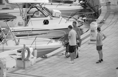 İtalya, Sicilya, Akdeniz, Marina di Ragusa (Ragusa Eyaleti); 9 Eylül 2022, gün batımında limanda halk, motorlu tekne ve lüks yatlar - EDITORIAL