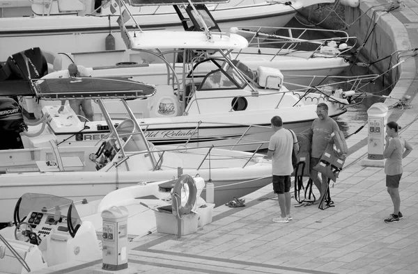 İtalya, Sicilya, Akdeniz, Marina di Ragusa (Ragusa Eyaleti); 9 Eylül 2022, gün batımında limanda halk, motorlu tekne ve lüks yatlar - EDITORIAL