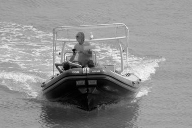 İtalya, Sicilya, Akdeniz, Marina di Ragusa (Ragusa Eyaleti); 10 Eylül 2022, limanda bir kauçuk teknede çift - EDITORIAL