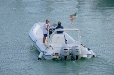 İtalya, Sicilya, Akdeniz, Marina di Ragusa (Ragusa Eyaleti); 10 Eylül 2022, limanda büyük bir kauçuk teknede erkekler - EDITORIAL