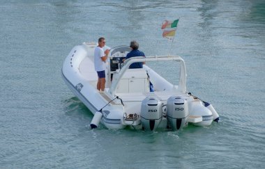 İtalya, Sicilya, Akdeniz, Marina di Ragusa (Ragusa Eyaleti); 10 Eylül 2022, limanda büyük bir kauçuk teknede erkekler - EDITORIAL