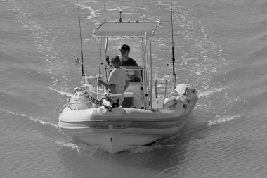 İtalya, Sicilya, Akdeniz, Marina di Ragusa (Ragusa Eyaleti); 11 Eylül 2022, limandaki lastik bir teknede balıkçılar - EDITORIAL