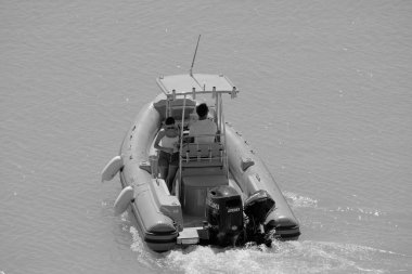 İtalya, Sicilya, Akdeniz, Marina di Ragusa (Ragusa Eyaleti); 11 Eylül 2022, limanda bir kauçuk teknede çift - EDITORIAL