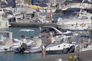 İtalya, Sicilya, Akdeniz, Marina di Ragusa (Ragusa Eyaleti); 11 Eylül 2022, limanda lüks bir yatta çift - EDITORIAL