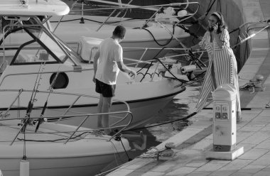 İtalya, Sicilya, Akdeniz, Marina di Ragusa (Ragusa Eyaleti); 11 Eylül 2022, limandaki bir motorlu teknede balıkçı - EDITORIAL