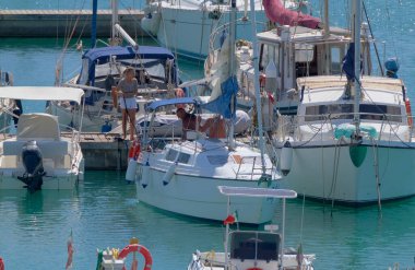 İtalya, Sicilya, Akdeniz, Marina di Ragusa (Ragusa Eyaleti); 13 Eylül 2022, limandaki bir yelkenli teknesinde erkekler - EDITORIAL