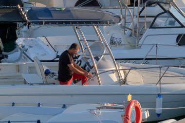 İtalya, Sicilya, Akdeniz, Marina di Ragusa (Ragusa Eyaleti); 13 Eylül 2022, limandaki bir motorlu teknede adam - EDITORIAL