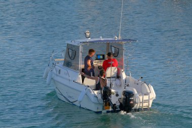 İtalya, Sicilya, Akdeniz, Marina di Ragusa (Ragusa Eyaleti); 13 Eylül 2022, limandaki bir motorlu teknede balıkçı - EDITORIAL