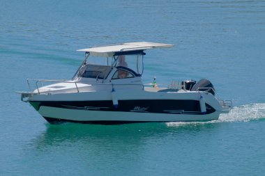 Taly, Sicilya, Akdeniz, Marina di Ragusa (Ragusa Eyaleti); 14 Eylül 2022, limandaki bir motorlu teknede adam - EDITORIAL