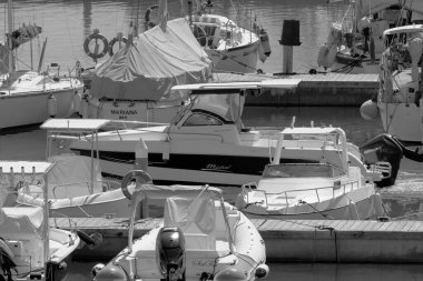 Taly, Sicilya, Akdeniz, Marina di Ragusa (Ragusa Eyaleti); 14 Eylül 2022, limandaki bir motorlu teknede adam - EDITORIAL