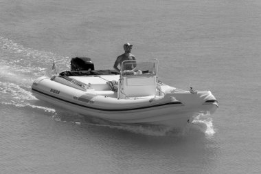 İtalya, Sicilya, Akdeniz, Marina di Ragusa (Ragusa Eyaleti); 14 Eylül 2022, limandaki kauçuk bir teknede adam - EDITORIAL