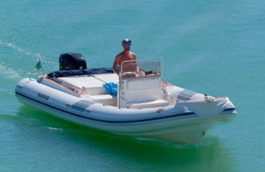 İtalya, Sicilya, Akdeniz, Marina di Ragusa (Ragusa Eyaleti); 14 Eylül 2022, limandaki kauçuk bir teknede adam - EDITORIAL