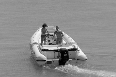 İtalya, Sicilya, Akdeniz, Marina di Ragusa (Ragusa Eyaleti); 14 Eylül 2022, limandaki kauçuk bir teknede erkekler - EDITORIAL