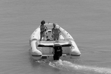 İtalya, Sicilya, Akdeniz, Marina di Ragusa (Ragusa Eyaleti); 14 Eylül 2022, limandaki kauçuk bir teknede erkekler - EDITORIAL