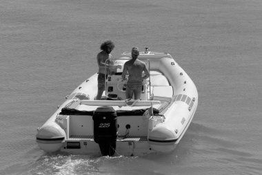 İtalya, Sicilya, Akdeniz, Marina di Ragusa (Ragusa Eyaleti); 14 Eylül 2022, limandaki kauçuk bir teknede erkekler - EDITORIAL