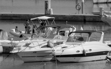 İtalya, Sicilya, Akdeniz, Marina di Ragusa (Ragusa Eyaleti); 15 Eylül 2022, limandaki kauçuk tekne ve lüks yatlarda yaşayan insanlar - EDITORIAL