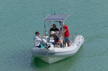 İtalya, Sicilya, Akdeniz, Marina di Ragusa (Ragusa Eyaleti); 15 Eylül 2022, limandaki lastik bir teknede balıkçılar - EDITORIAL