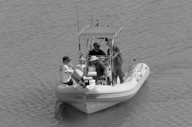 İtalya, Sicilya, Akdeniz, Marina di Ragusa (Ragusa Eyaleti); 15 Eylül 2022, limandaki lastik bir teknede balıkçılar - EDITORIAL