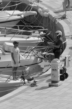 İtalya, Sicilya, Akdeniz, Marina di Ragusa (Ragusa Eyaleti); 16 Eylül 2022, limanda lüks bir yatta adam - EDITORIAL