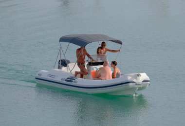 İtalya, Sicilya, Akdeniz, Marina di Ragusa (Ragusa Eyaleti); 19 Eylül 2022, limandaki kauçuk bir teknede insanlar - EDITORIAL