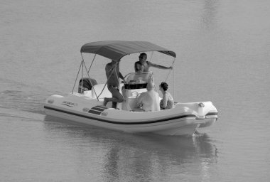 İtalya, Sicilya, Akdeniz, Marina di Ragusa (Ragusa Eyaleti); 19 Eylül 2022, limandaki kauçuk bir teknede insanlar - EDITORIAL