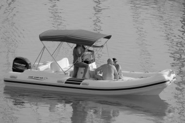 İtalya, Sicilya, Akdeniz, Marina di Ragusa (Ragusa Eyaleti); 19 Eylül 2022, limandaki kauçuk bir teknede insanlar - EDITORIAL