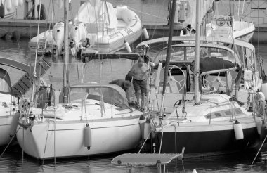 İtalya, Sicilya, Akdeniz, Marina di Ragusa (Ragusa ili); 26 Eylül 2022, limandaki bir yelkenli teknesinde çift - EDITORIAL