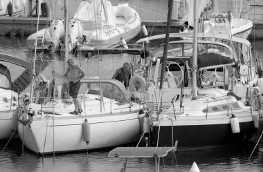 İtalya, Sicilya, Akdeniz, Marina di Ragusa (Ragusa ili); 26 Eylül 2022, limandaki bir yelkenli teknesinde çift - EDITORIAL