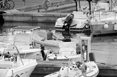 İtalya, Sicilya, Akdeniz, Marina di Ragusa (Ragusa Eyaleti); 29 Eylül 2022, limandaki kauçuk bir tekne ve lüks yatlarda adam - EDITORIAL