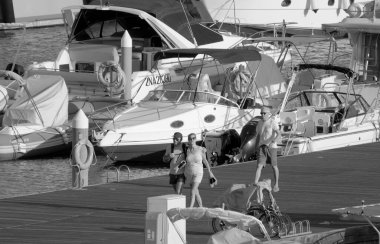 Taly, Sicilya, Akdeniz, Marina di Ragusa (Ragusa ili); 1 Ekim 2022, limandaki insanlar ve lüks yatlar - EDITORIAL