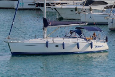 İtalya, Sicilya, Akdeniz, Marina di Ragusa (Ragusa Eyaleti); 5 Ekim 2022, limandaki bir yelkenli teknesinde adam - EDITORIAL