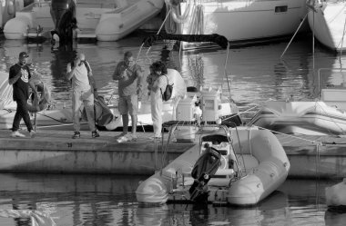 İtalya, Sicilya, Akdeniz, Marina di Ragusa (Ragusa ili); 5 Ekim 2022, limanda insanlar ve motorlu tekneler - EDITORIAL