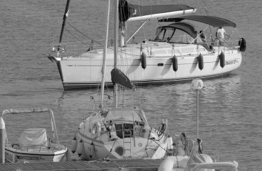 İtalya, Sicilya, Akdeniz, Marina di Ragusa (Ragusa ili); 6 Ekim 2022, limandaki bir yelkenli teknesinde erkekler - EDITORIAL