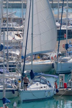 İtalya, Sicilya, Akdeniz, Marina di Ragusa (Ragusa ili); 16 Ekim 2022, limandaki bir yelkenli teknesinde insanlar - EDITORIAL