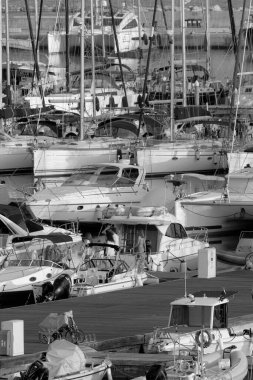 İtalya, Sicilya, Akdeniz, Marina di Ragusa (Ragusa ili); 21 Ekim 2022, limandaki insanlar, motorlu tekneler ve lüks yatlar - EDITORIAL